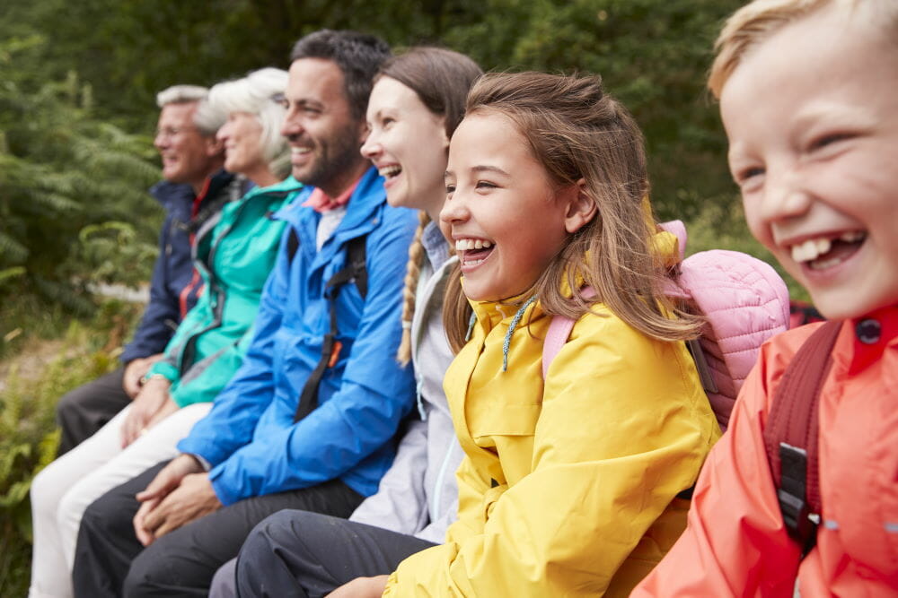 side view of multi-generation family in colorful jackets laughing