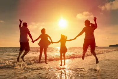 family enjoying the beach in sunset