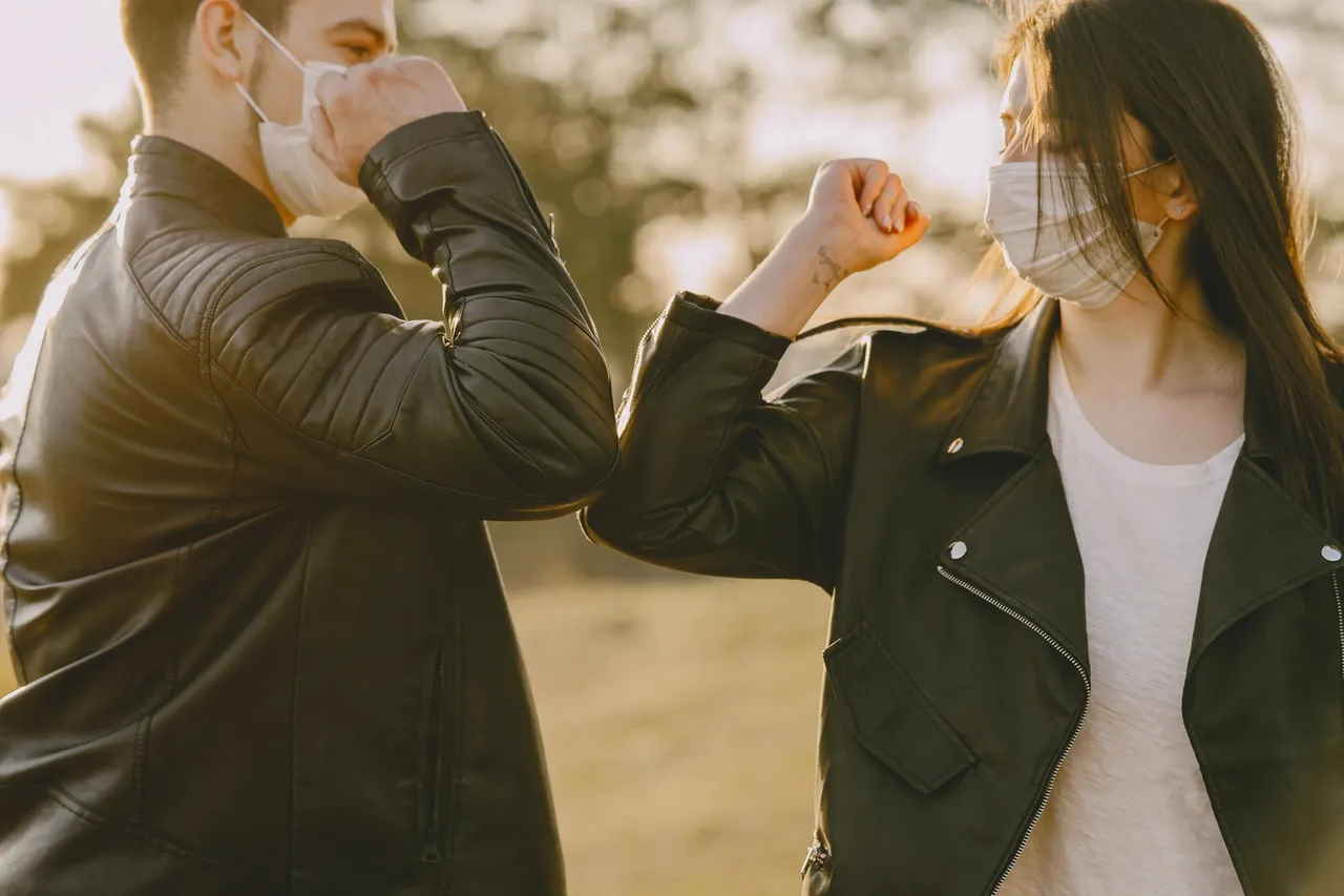 man and woman doing coronavirus handshake