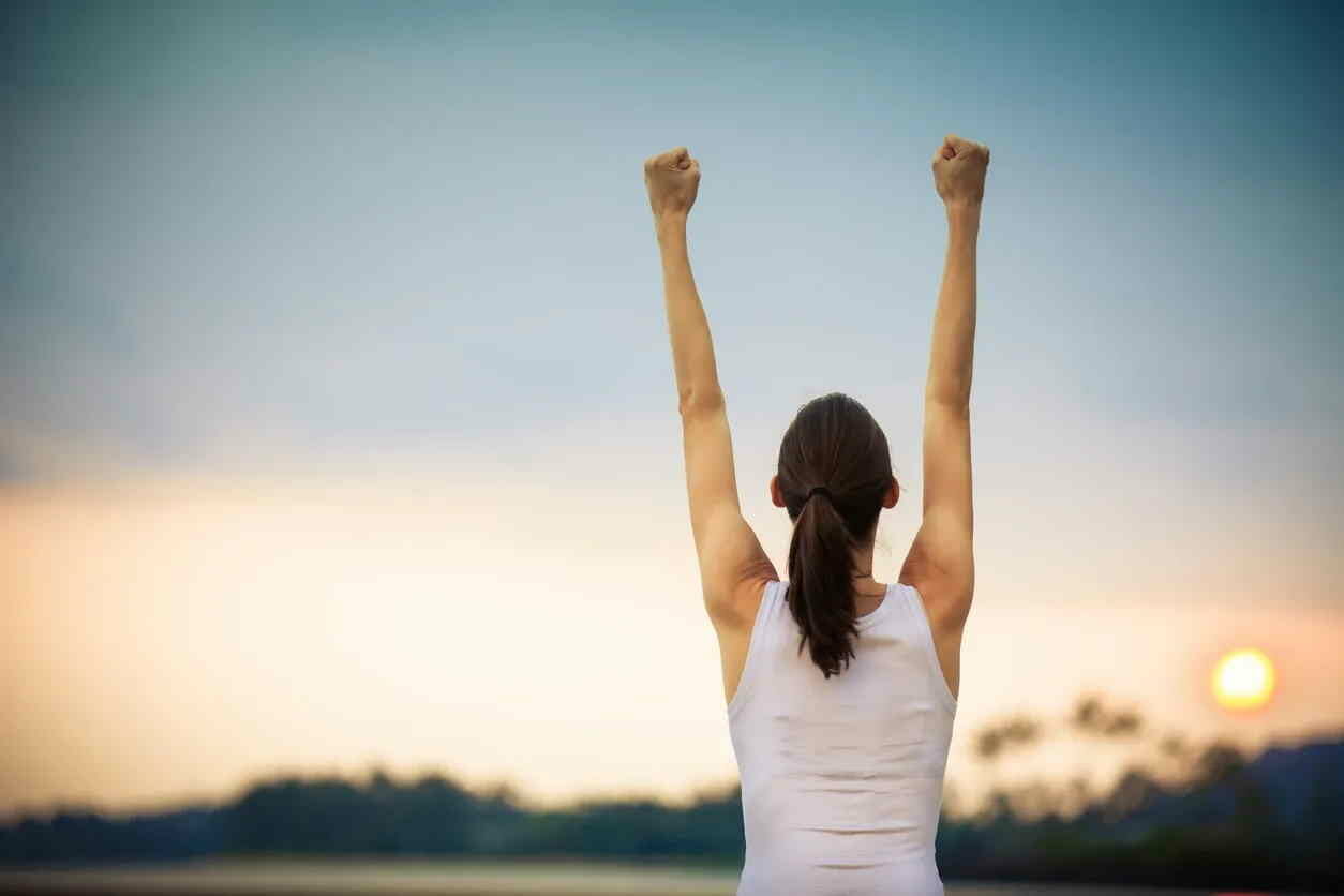 woman raising her hands in the air