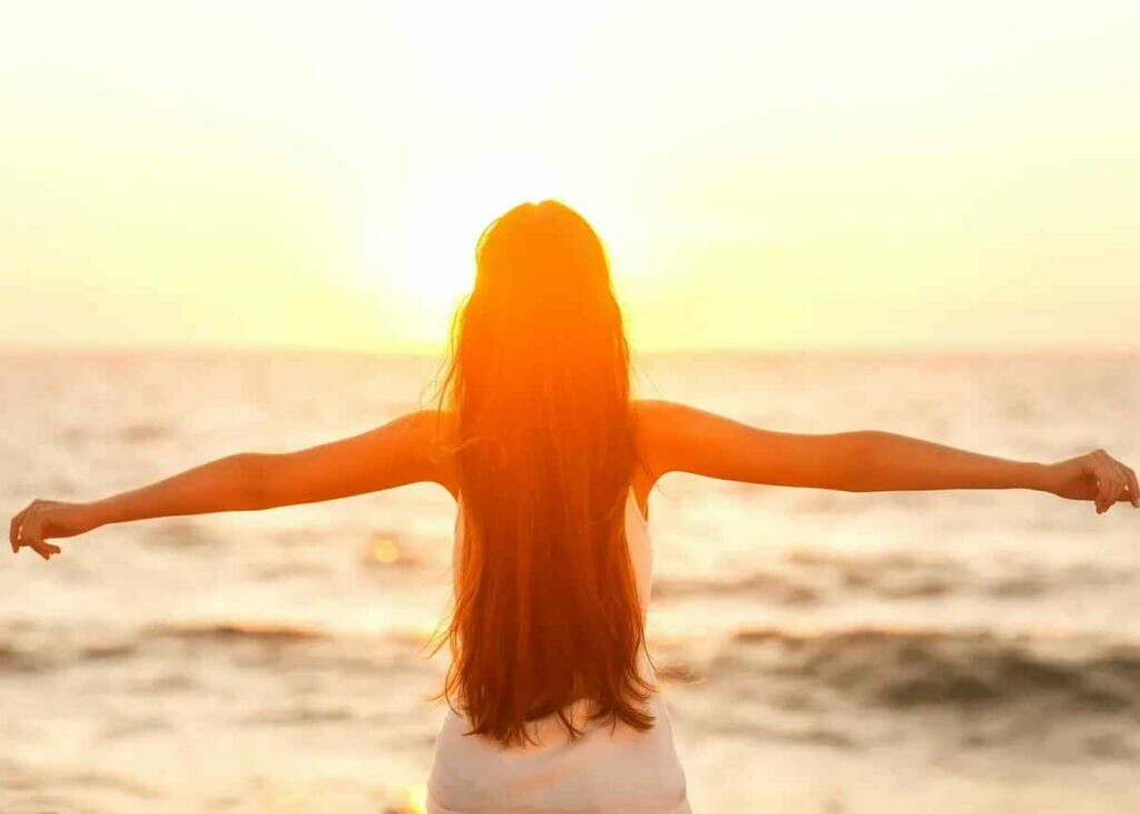 woman feeling free looking at sunset