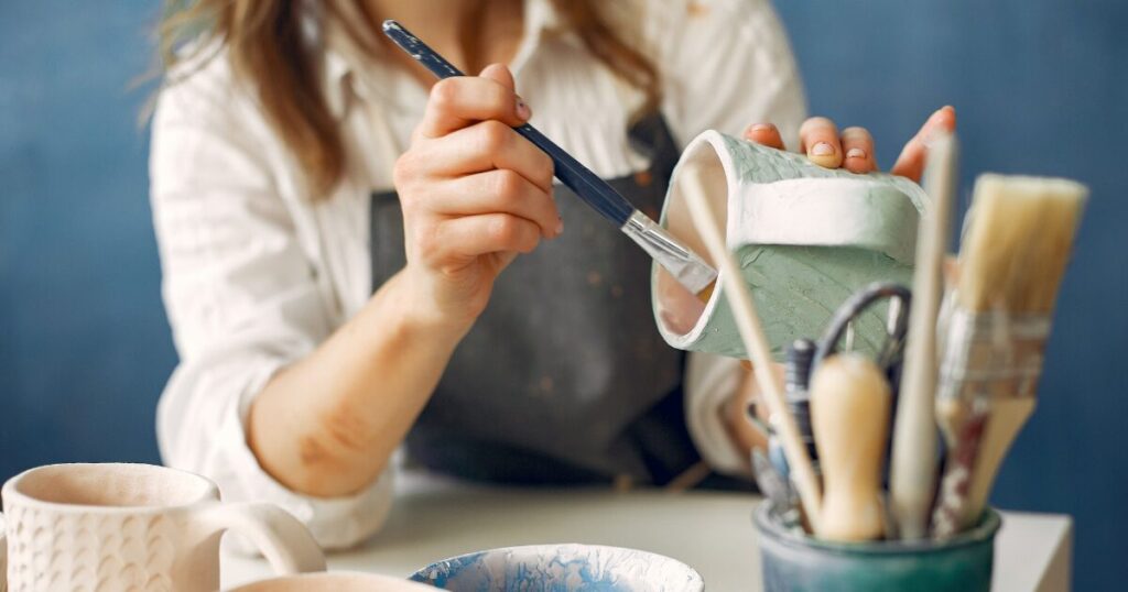 woman painting ceramic mug to manage stress from adhd child